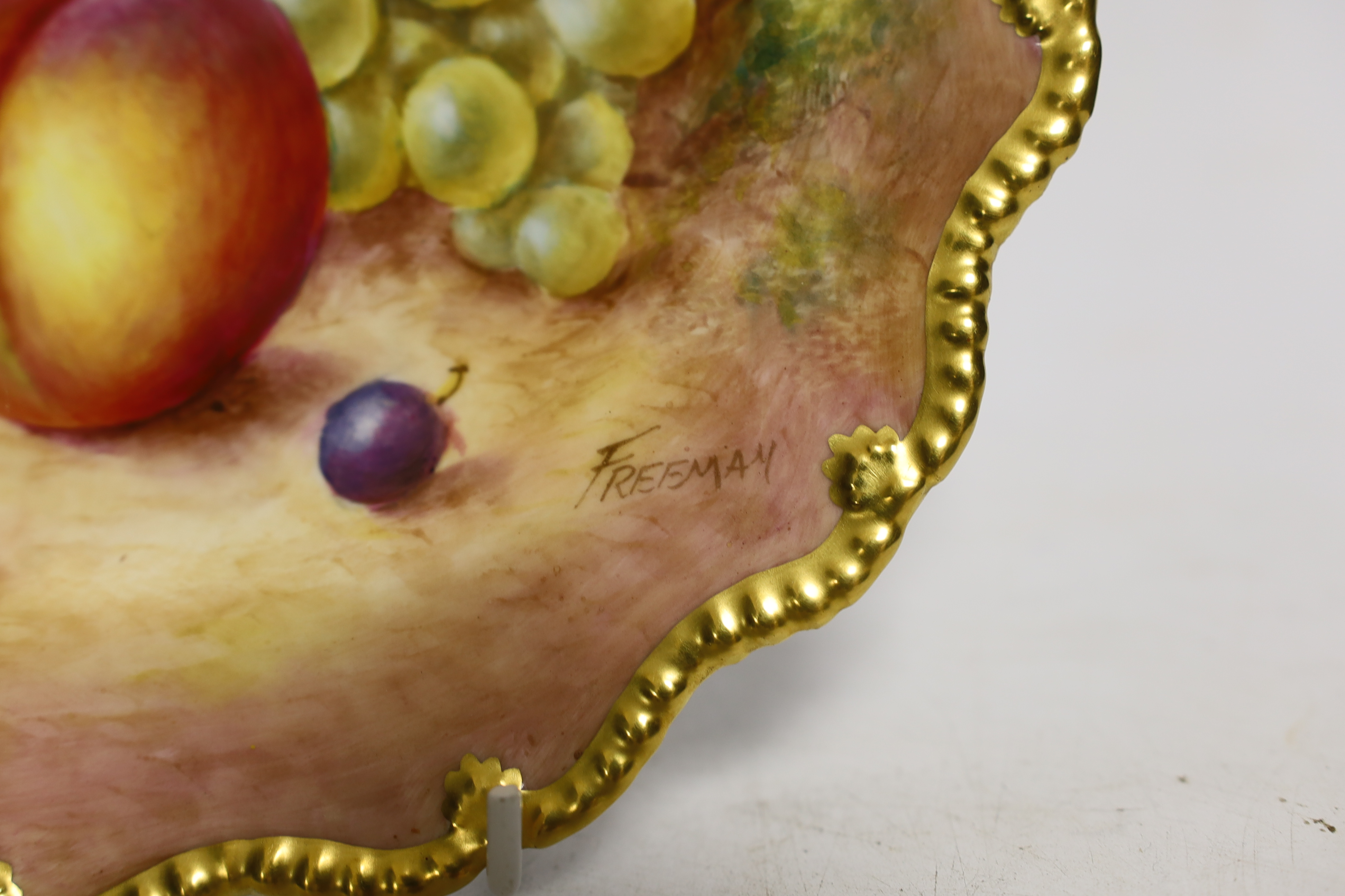 A pair of Royal Worcester fruit painted plates, post war, signed Freeman, 22.5cm
